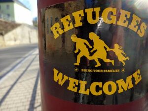 Refugees Welcome - Bring your Families - Sticker on a street lamp in Sebnitz - March 21, 2022